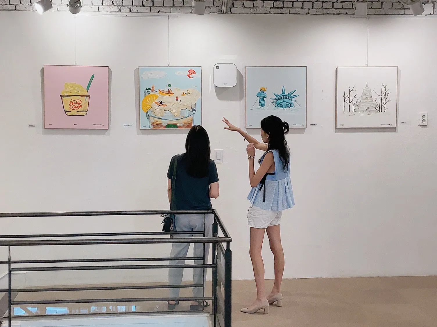 Visitors looking at Hello Madison canvases in a gallery